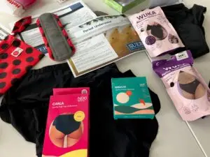 On a table a selection of period pants and packaging as well as reusable pads are laid out.