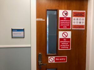 Door to research lab covered in no admittance signs.