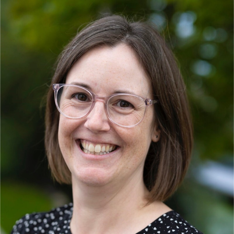 White woman with shoulder length brown hair and glasses