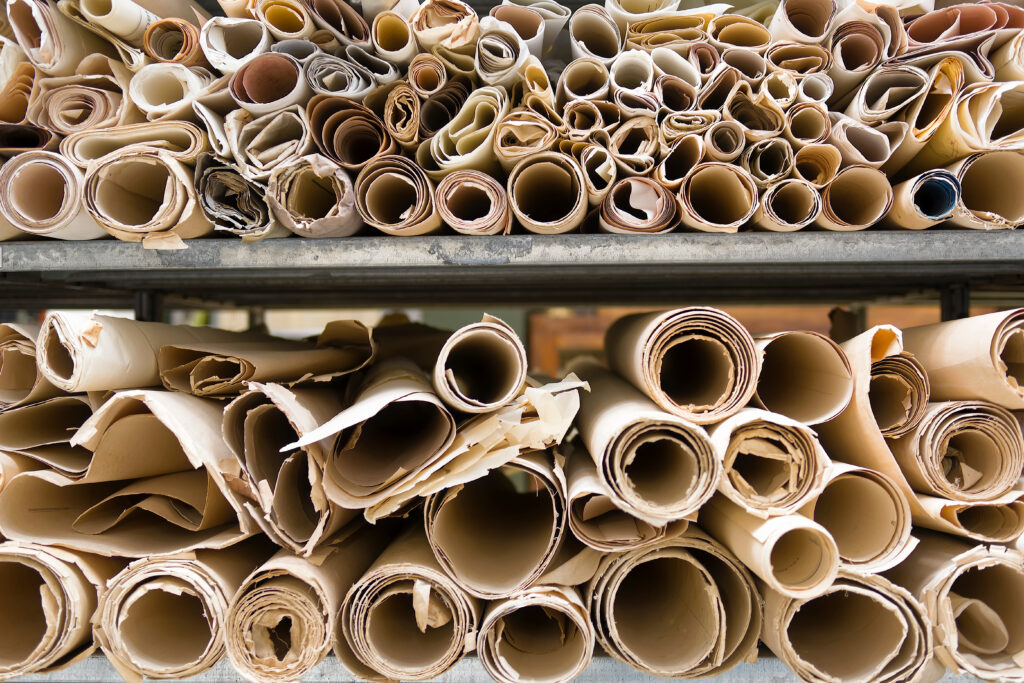 two shelves with stacks and stacks of old, fraying rolled up maps or posters.