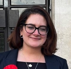 White woman with shoulder length brown hair and glasses