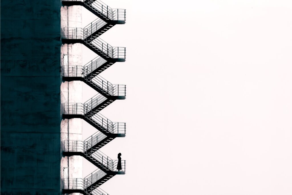 Illustration of a person climbing up a tall staircase on the outside of a building