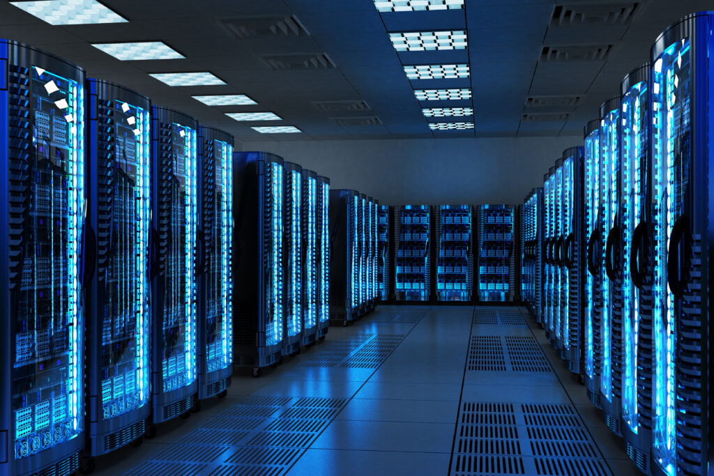 Photo of data centre looking along a long line of computer mainframes glowing an eerie blue.