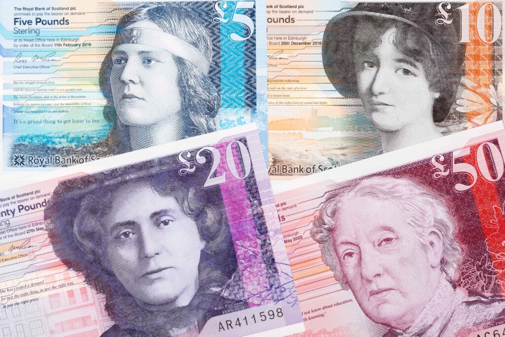 A close up photo of four Scottish bank notes - the £5, £10, £20, and £50. On each of them, the reverse shown has an image of a historic female figure featured on it.